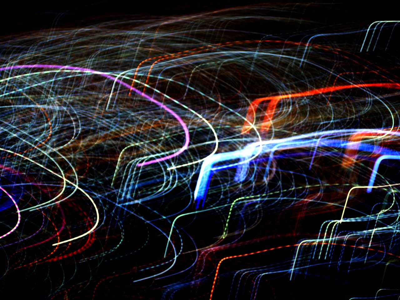team-04 Vibrant abstract image featuring colorful light trails against a dark background.